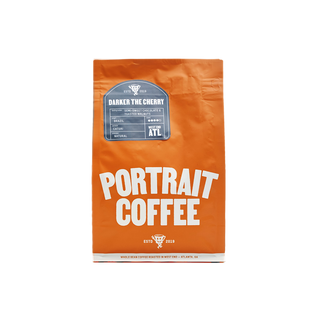 Orange Portrait Coffee bag centered on a black background.