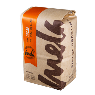 Decaf Signature Blend coffee bag with a vivid orange label on kraft paper