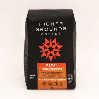 Close-up of a black Higher Grounds Coffee decaf bag with white branding and a red geometric star