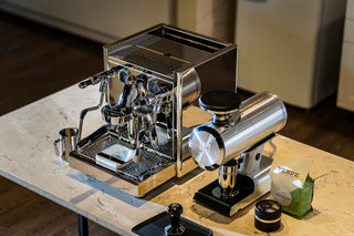 ECM Technika VI espresso machine with chrome finish and blue gauge faces on a marble countertop.