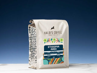 Kaldi's Coffee Ethiopia Ardi Natural bag with colorful label and dotted side panel on a white surface against a blue gradient backdrop