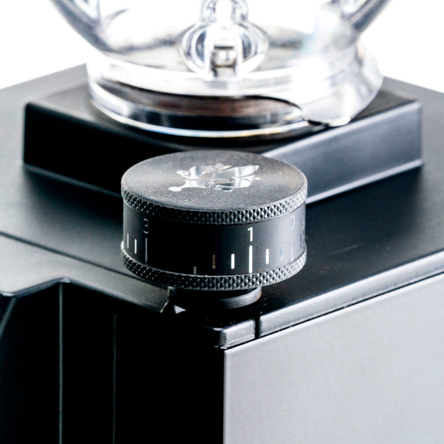 Front close up of Eureka Mignon Zero 65 grinder with portafilter mounted in the cradle.