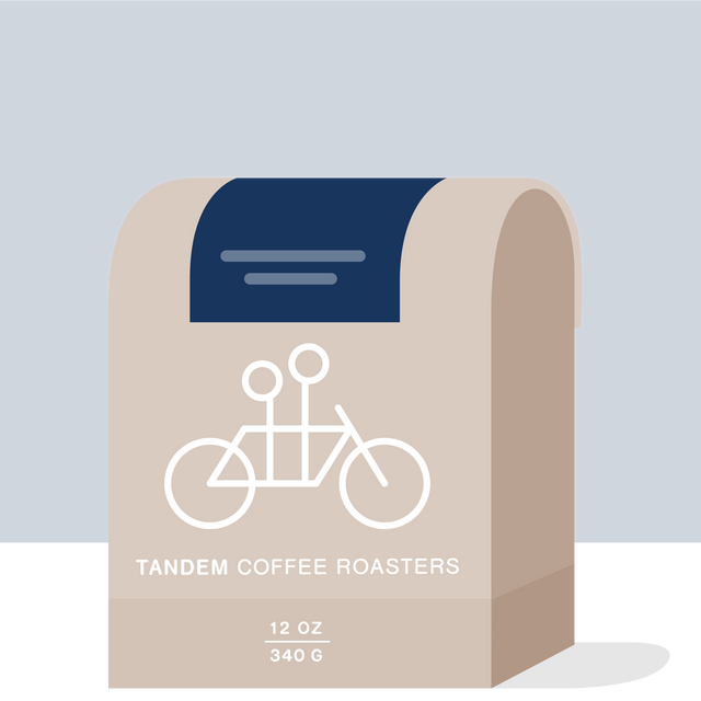Colombia Faver Ninco Field Blend coffee bag with beige label and white bicycle graphic on a dark blue background.