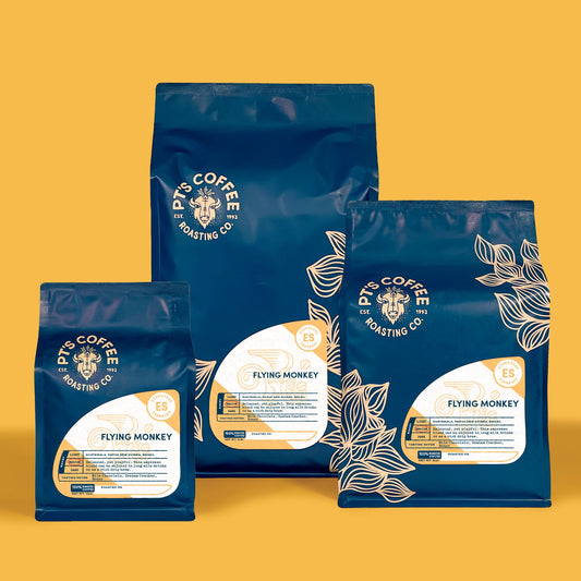 Flying Monkey Espresso three bean blend bags arranged on a warm yellow backdrop
