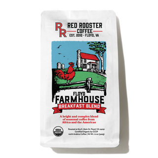 Golden mug beside Organic Floyd Farmhouse Breakfast Blend bag on a cafe counter