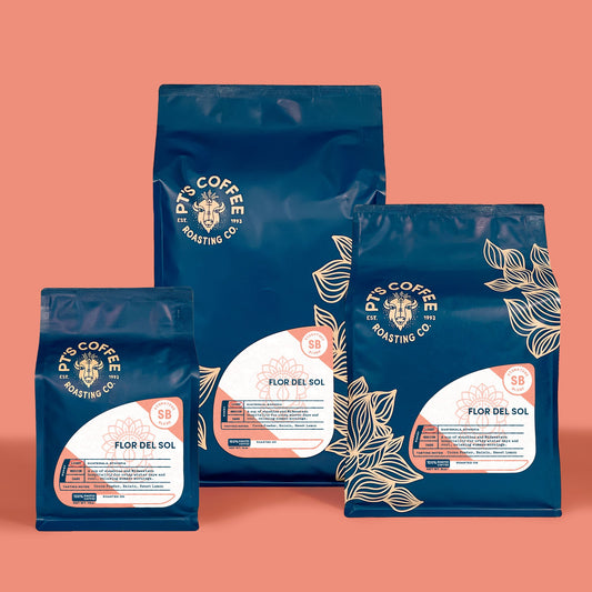 Flor del Sol Signature Blend coffee bags with citrus and caramel notes on a peach backdrop
