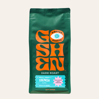 Close-up of Heavy Feels French green coffee bag with bold orange logo