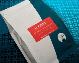 Il Primo espresso packaging with bold red label against teal background