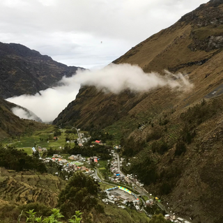 Remote Peruvian highland valley with rugged mountains and a small village at the base, illustrating the remote coffee terroir.