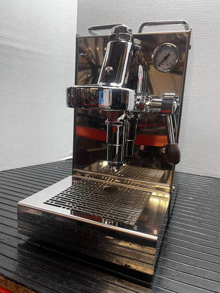 Close up of Lucca Solo espresso machine group head with chrome finish and pressure gauge