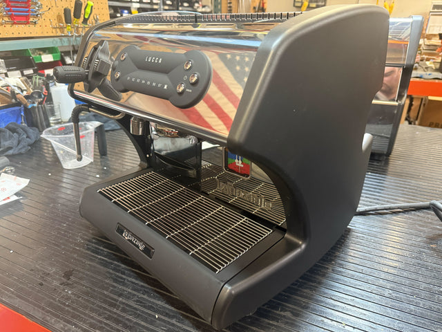 Open Box LUCCA A53 Mini espresso machine with chrome body and front control panel in workshop.