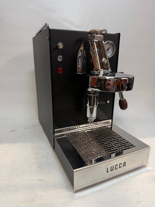 Open Box Lucca Solo espresso machine front view with chrome portafilter and pressure gauge on black body, LUCCA logo on the drip tray