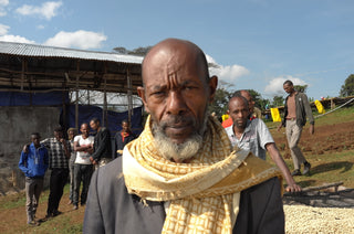 Man with a patterned scarf at a coffee drying yard in Ethiopia