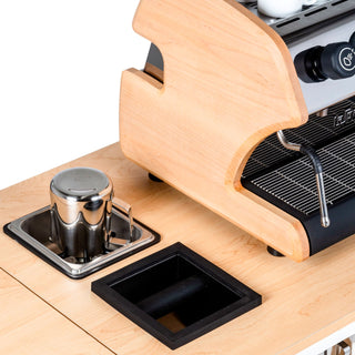 Partial view of a Klassy Karts mobile coffee cart with curved wooden housing and visible espresso gear