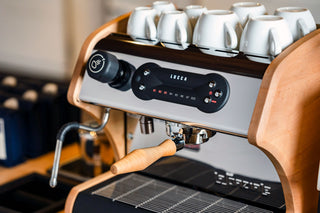 Close-up of the LUCCA A53 Direct Plumb espresso machine control panel with a portafilter visible.