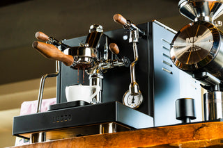 LUCCA 58mm Wood Bottomless Portafilter with wood handle mounted on an espresso machine
