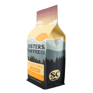 Angled shot of the High Desert Sunrise bag showing the label and mountain sunset artwork