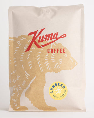 Close up of Sun Bear Coffee bag showing beige kraft wrap and the round yellow Sun Bear badge.
