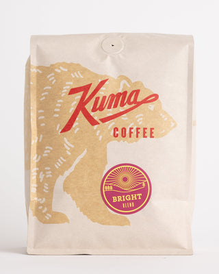 Kraft coffee bag with bold red script logo and Bright Blend badge at the lower right.