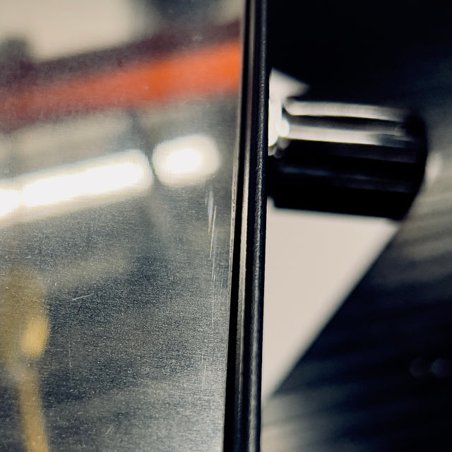 Close-up of the Profitec GO metal edge showing brushed steel surface and a narrow vertical seam between panels.