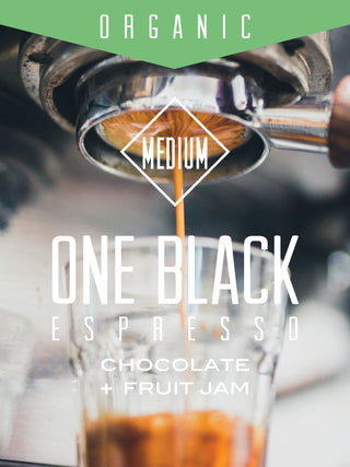 Espresso being pulled into a glass with a medium roast badge and an organic banner above