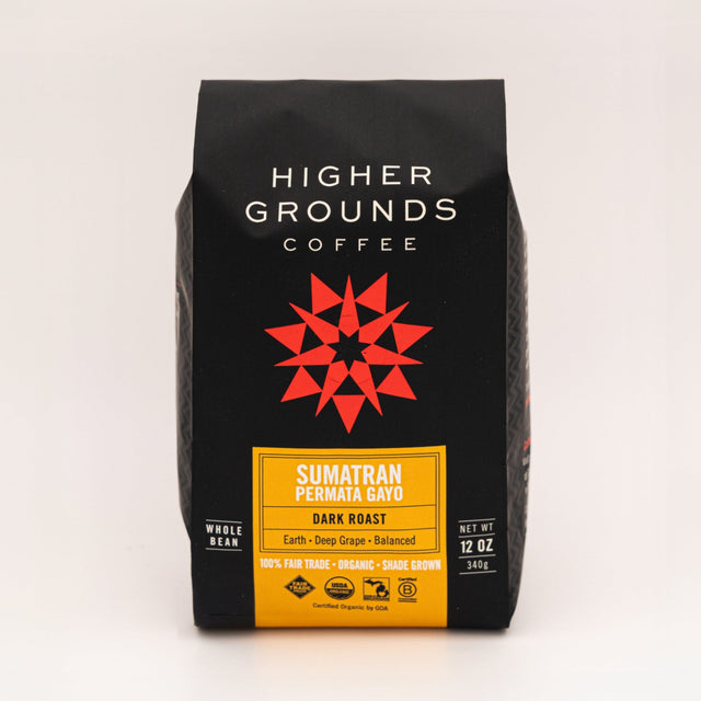 Sumatran Permata Gayo coffee bag from Higher Grounds on a wooden table with mint leaves, chocolate pieces, and coffee beans nearby.