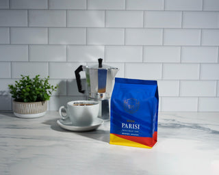 Espresso Parisi coffee bag on a marble kitchen counter with a moka pot and a white cup