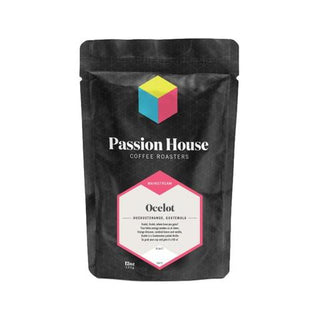 Front view of a Passion House Ocelot Guatemala coffee bag with hexagonal label on a black package