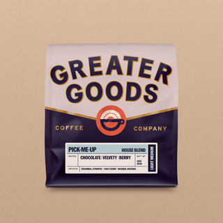 Partial view of Pick-Me-Up House Blend coffee bag with bold purple lettering on a white label against a tan backdrop