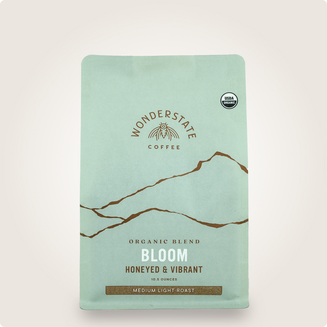 Mint green Organic Bloom coffee bag from Wonderstate with mountains graphic and USDA Organic badge