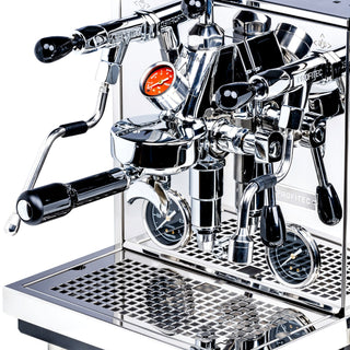 Close-up of chrome Profitec Drive with the portafilter attached and gauges visible on the front panel.