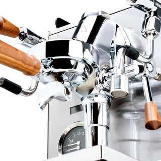 Front close-up of Profitec JUMP showing pressure gauge and chrome body with wooden portafilter handle.