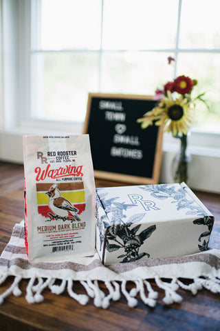 Waxwing All-Purpose Blend coffee bag with Red Rooster branding on a counter.