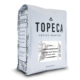 Topeca Signature Espresso Blend coffee bag with bold TOPECA lettering and a botanical side panel.