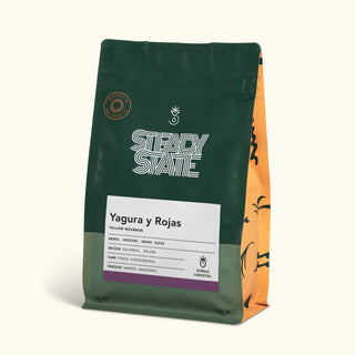 Yagura y Rojas Yellow Bourbon coffee bag with a dark green front panel an orange striped side and a label reading Yagura y Rojas