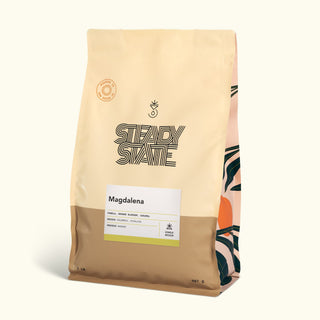 Magdalena coffee bag with white label on pale beige packaging and a yellow accent at the bottom.