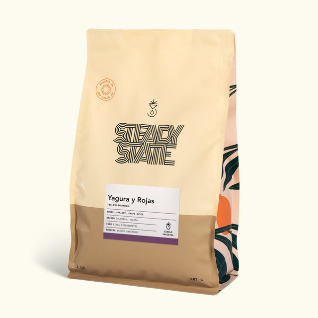 Yagura y Rojas Yellow Bourbon bag angled to reveal a white information sheet with purple border on the front