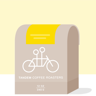 Sun Lamp Decaf packaging on bright yellow background with beige label and white bicycle graphic