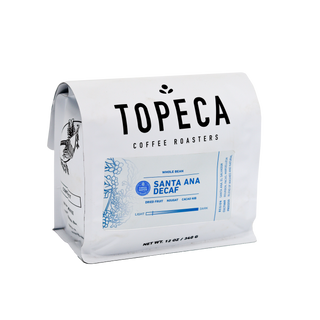 Close-up of a white Santa Ana Swiss Water Decaf coffee bag with bold TOPECA lettering