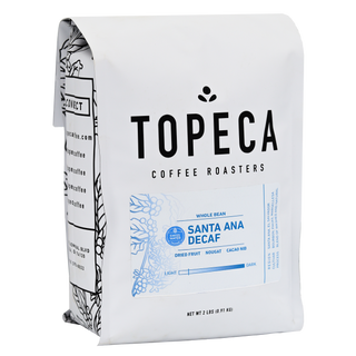 Angled view of a white Santa Ana Decaf coffee bag with blue printed panel and floral artwork