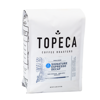 White Topeca coffee bag with large TOPECA text and decorative leaf illustration on the side