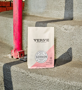 Sermon Espresso coffee bag by Verve placed on concrete steps beside a pink pipe