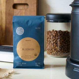Blueboon whole bean coffee bag on a kitchen counter beside a jar of roasted beans