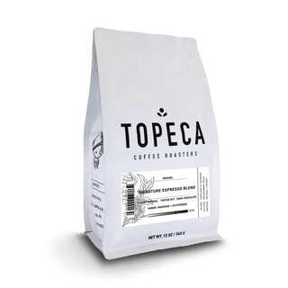 Topeca Signature Espresso Blend bag angled with white packaging and red label reading El Salvador Manzano.