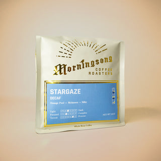 White coffee bag with a blue Stargaze Decaf label and a sunburst motif.
