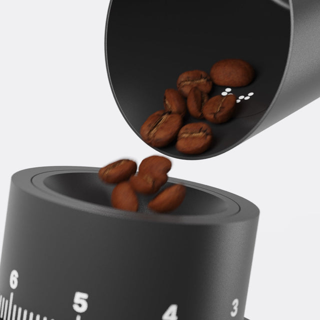 Subscale palm sized dosing scale with coffee beans pouring into the dark chamber and LEDs visible through the shell