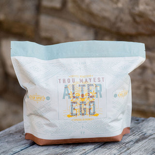Alter Ego coffee bag with a white body a pale blue top and a brown base on a wooden surface