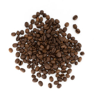 Roasted coffee beans scattered across a white surface