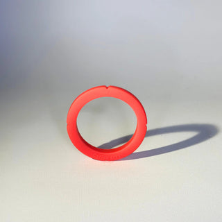 Red silicone group head gasket shown on a white surface.