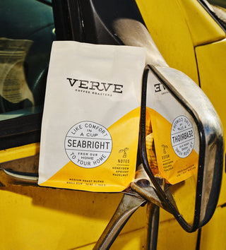 Seabright House Blend coffee bag resting on a yellow vehicle with white and yellow packaging and a circular Seabright label.